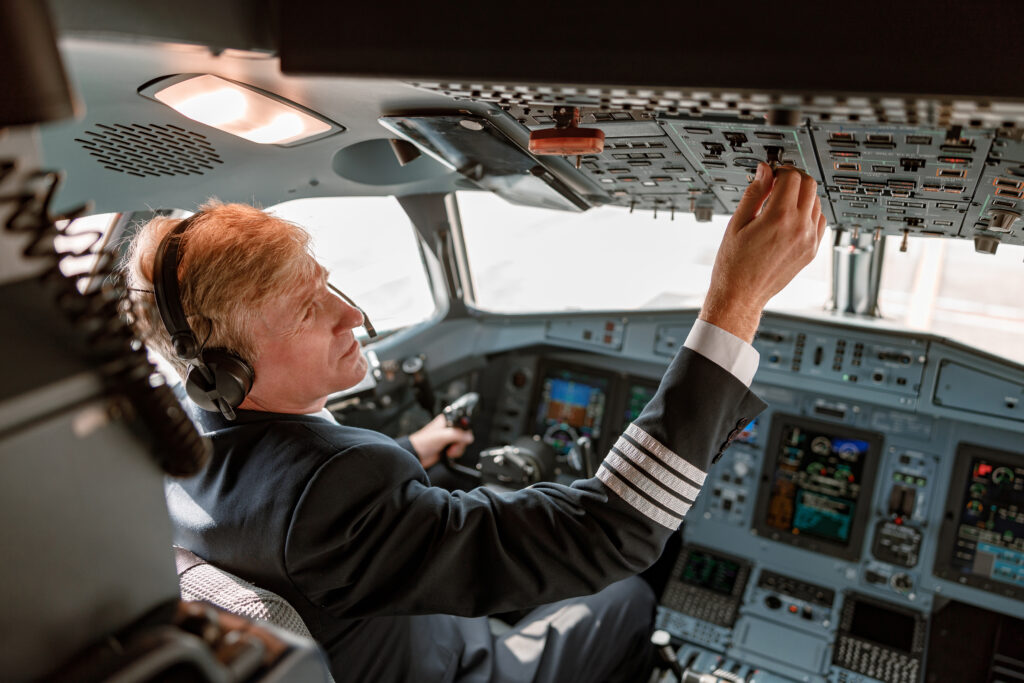 male pilot turning switch on overhead panel in coc 2022 03 24 16 00 01 utc 1024x683