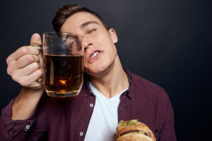 man with beer mug and hamburger in hands fun lifes 2024 07 05 23 09 36 utc scaled