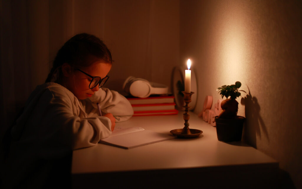 schoolgirl uses candlelight to writes and reads in 2023 11 27 05 06 12 utc scaled