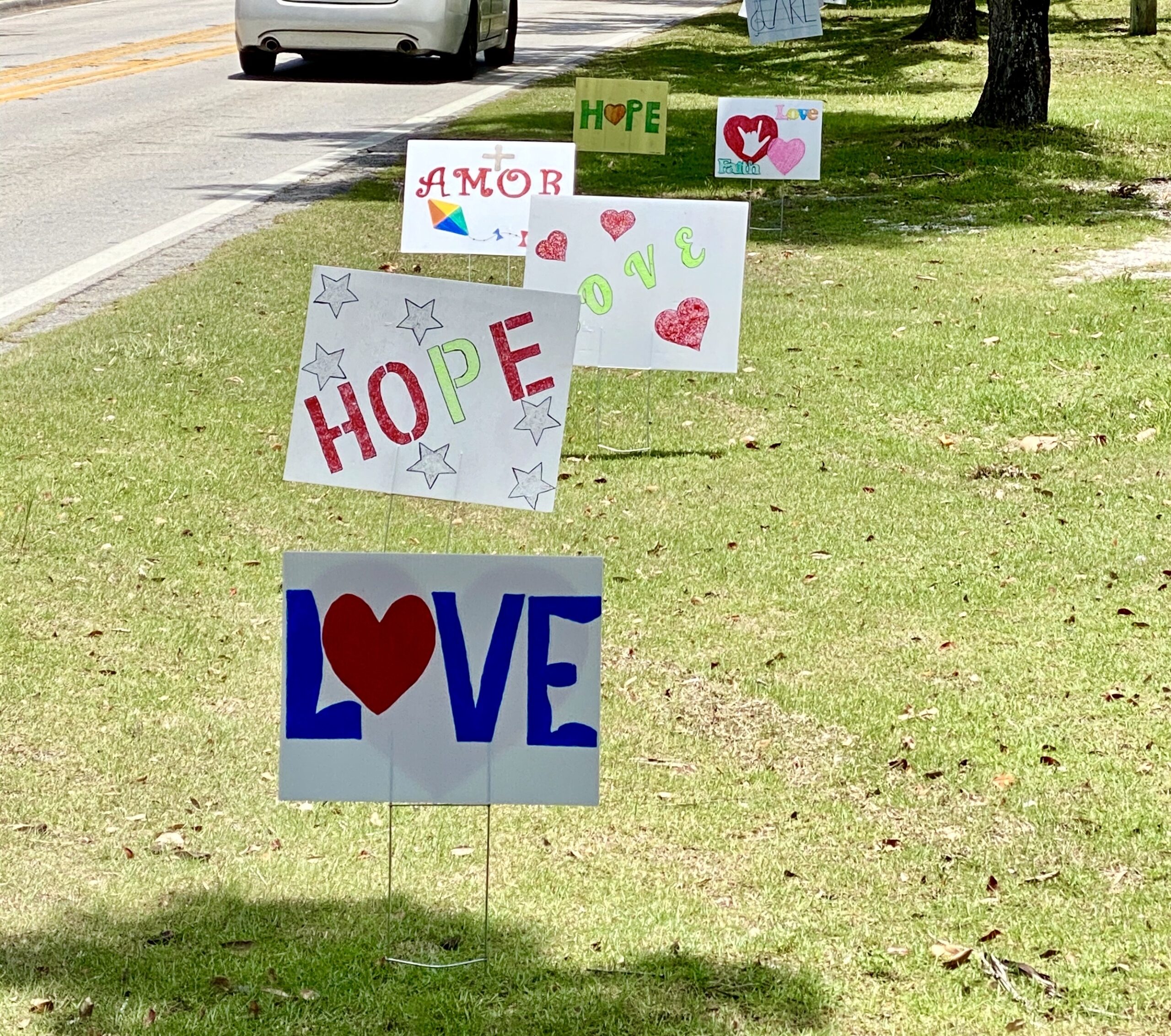 a yard by the road with signs that say hope love 2023 11 27 05 00 33 utc scaled