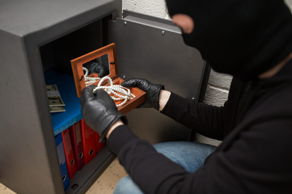 thief stealing valuables from safe at crime scene 2023 11 27 05 01 06 utc scaled