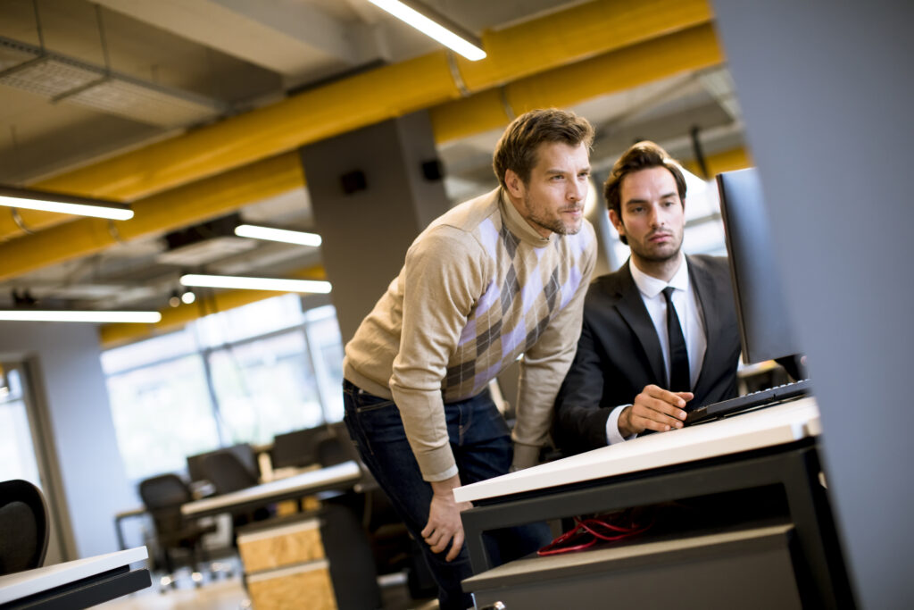 two young businessmen discussing in office by the 2023 11 27 04 52 37 utc 1 scaled