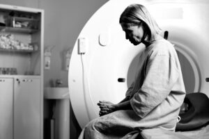 sad woman sitting on ct scanner bed 2024 04 25 19 14 37 utc scaled